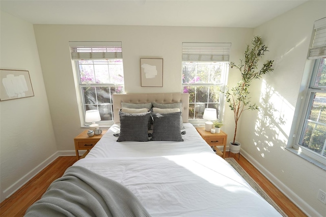 bedroom with wood-type flooring and multiple windows