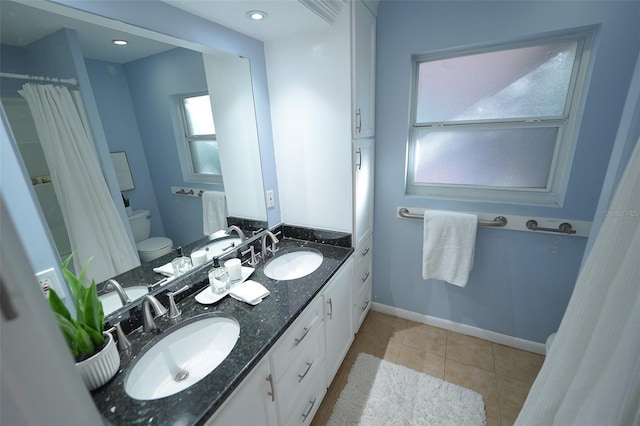 bathroom with tile patterned flooring, vanity, and toilet