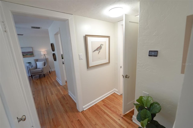 hallway with light hardwood / wood-style flooring