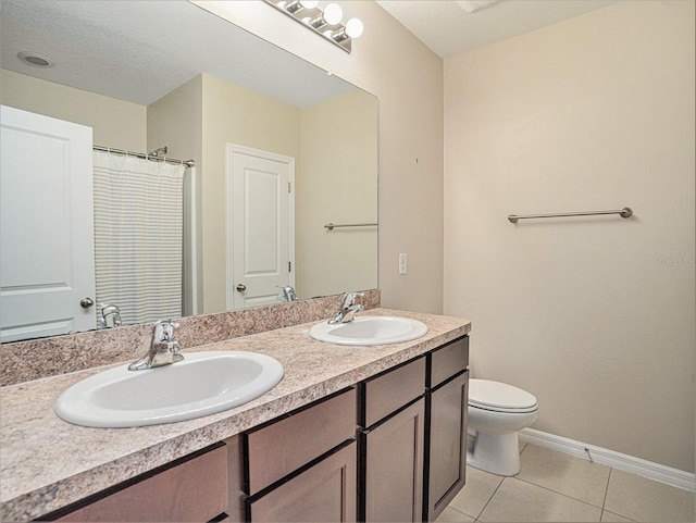 bathroom featuring vanity, a textured ceiling, toilet, and tile patterned flooring