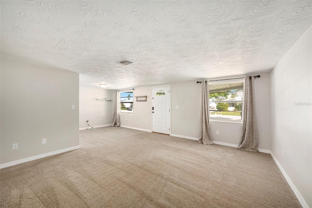 empty room featuring light carpet and a textured ceiling