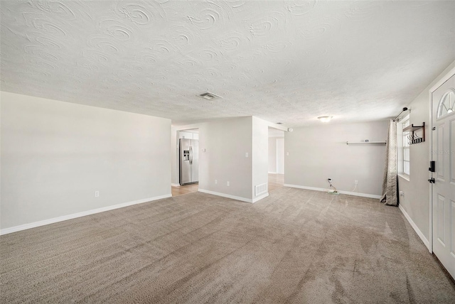 interior space featuring light carpet and a textured ceiling