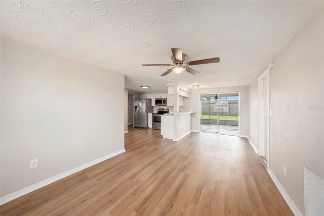 unfurnished living room with a textured ceiling, light wood-type flooring, and ceiling fan