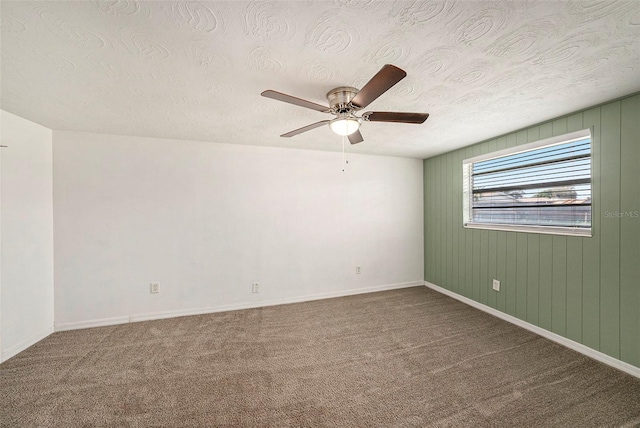 carpeted spare room with a textured ceiling and ceiling fan