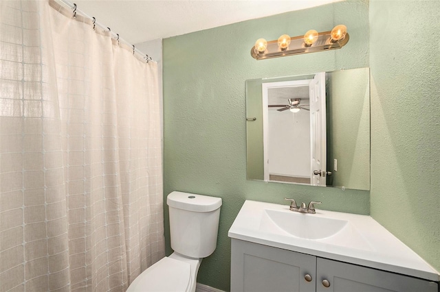 bathroom featuring toilet, vanity, a shower with shower curtain, and ceiling fan