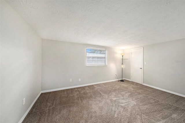 unfurnished room featuring carpet flooring and a textured ceiling