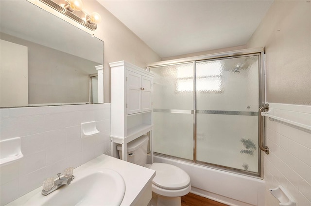 full bathroom featuring tile walls, shower / bath combination with glass door, toilet, and hardwood / wood-style flooring