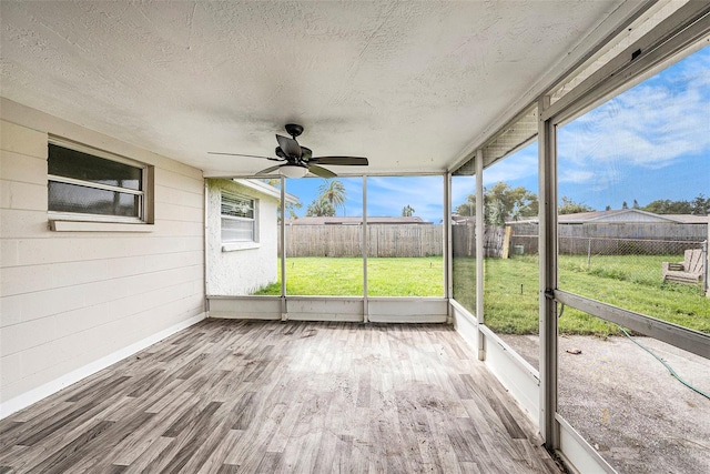 unfurnished sunroom with ceiling fan