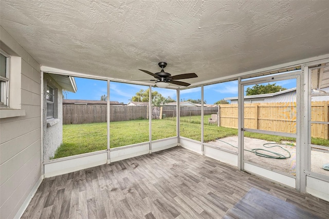 unfurnished sunroom with ceiling fan