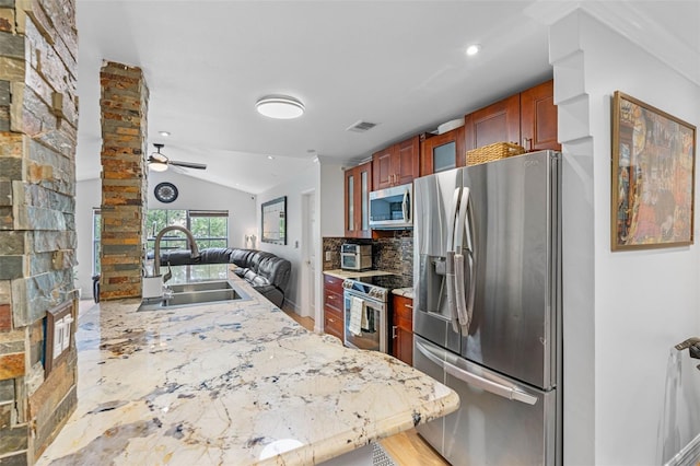 kitchen featuring decorative backsplash, sink, vaulted ceiling, appliances with stainless steel finishes, and ceiling fan