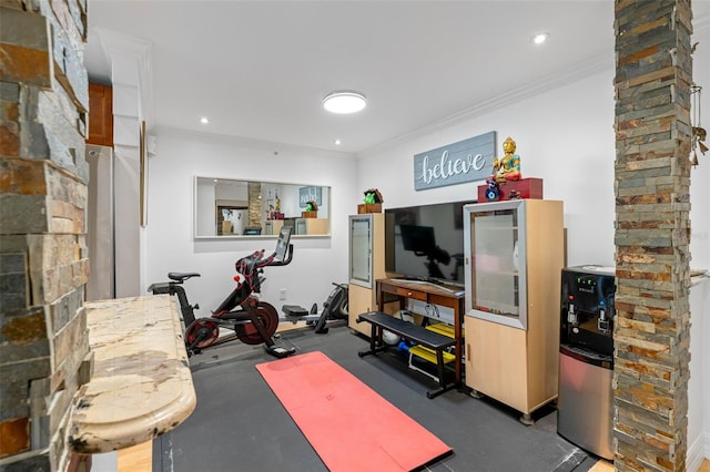 workout room featuring ornamental molding and ornate columns