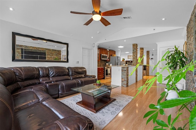 living room with lofted ceiling, light wood-type flooring, and ceiling fan