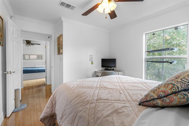 bedroom with ornamental molding, light hardwood / wood-style flooring, and ceiling fan