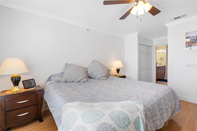 bedroom with a closet, crown molding, ensuite bathroom, light hardwood / wood-style floors, and ceiling fan