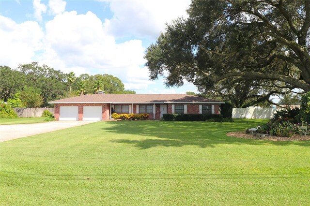 ranch-style home with fence, a front lawn, concrete driveway, brick siding, and a garage