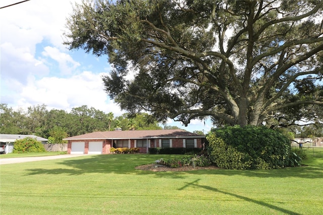 single story home with brick siding, an attached garage, driveway, and a front lawn