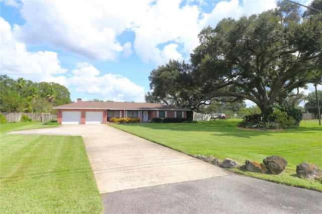 ranch-style home with fence, a front lawn, concrete driveway, an attached garage, and brick siding