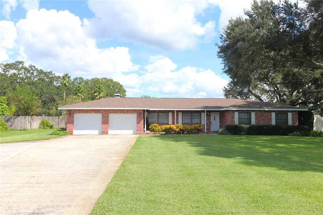 ranch-style house featuring concrete driveway, a front lawn, an attached garage, fence, and brick siding