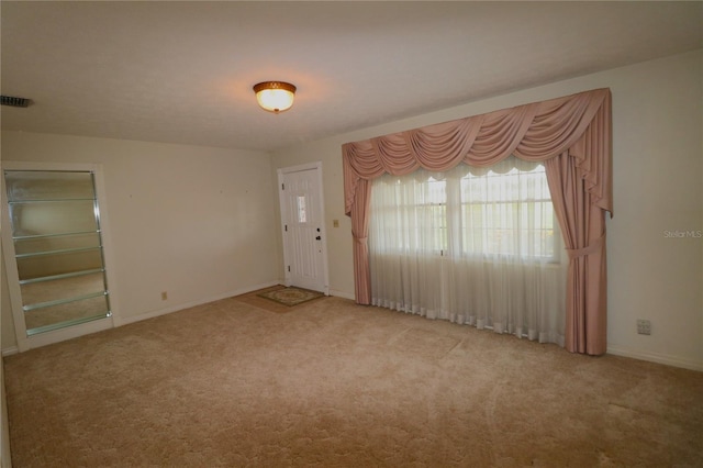 carpeted spare room with baseboards and visible vents