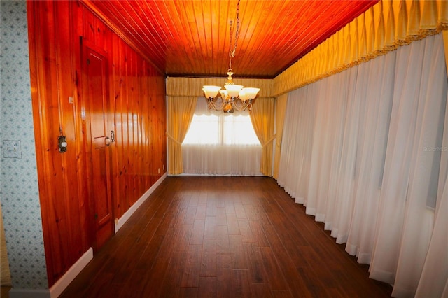 empty room featuring wooden ceiling, a notable chandelier, and dark wood finished floors