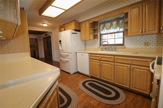 kitchen featuring hardwood / wood-style floors, sink, decorative backsplash, and white appliances