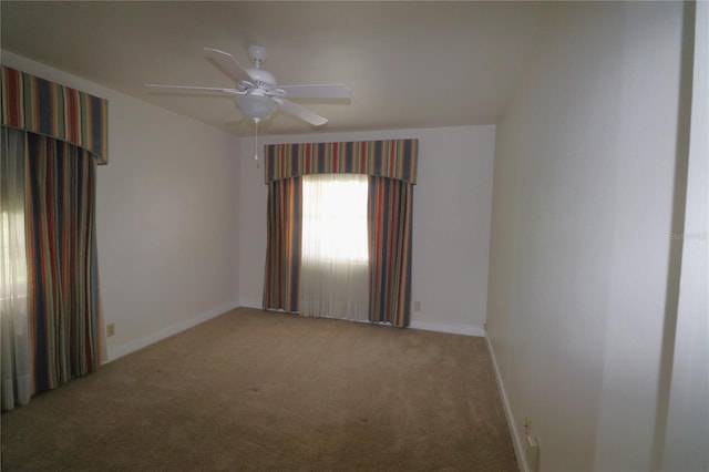 empty room featuring a ceiling fan, baseboards, and carpet floors