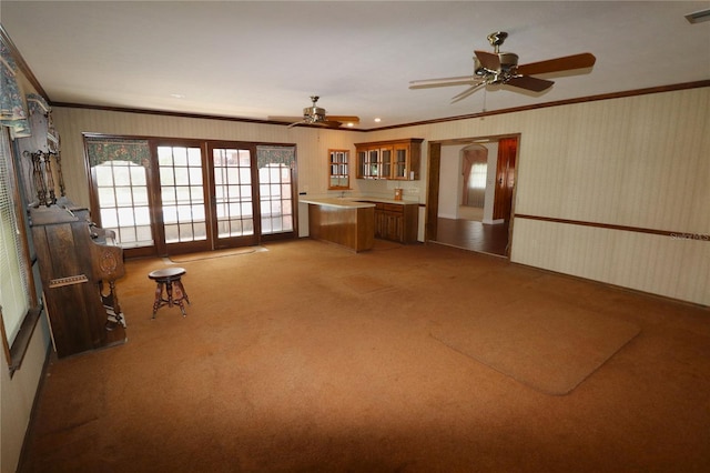 unfurnished living room featuring french doors, ornamental molding, and carpet