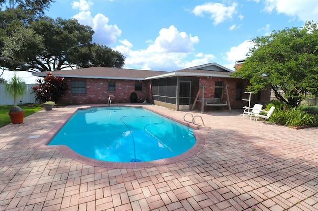 view of swimming pool featuring a patio area, a sunroom, a fenced in pool, and fence