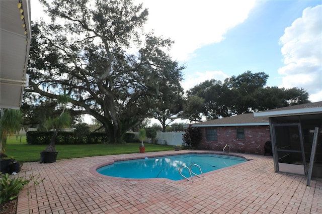 view of swimming pool featuring a patio area, a fenced in pool, a sunroom, and a yard