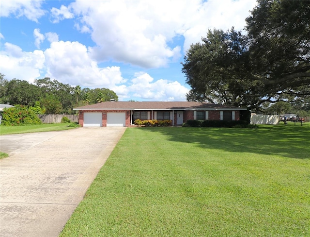 ranch-style house with fence, a front lawn, an attached garage, driveway, and brick siding