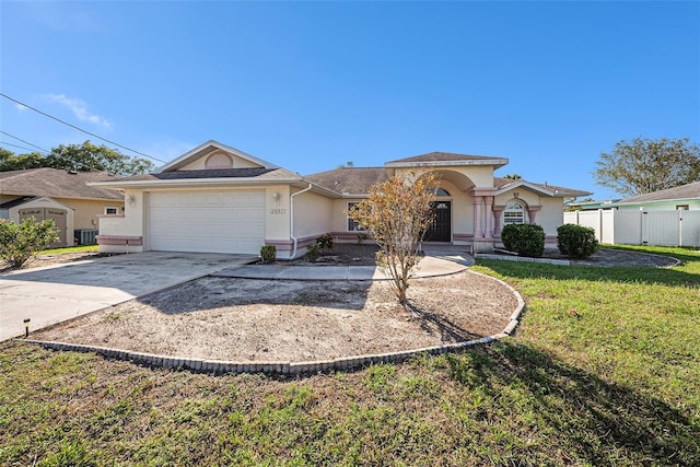 ranch-style home with a front yard, a garage, and central AC unit