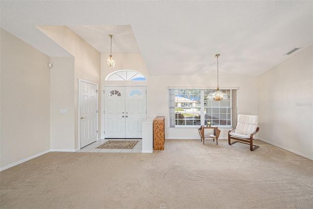 entrance foyer with light colored carpet, a textured ceiling, and lofted ceiling