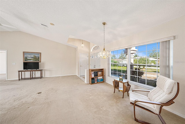 living area with carpet flooring, a textured ceiling, a chandelier, and vaulted ceiling