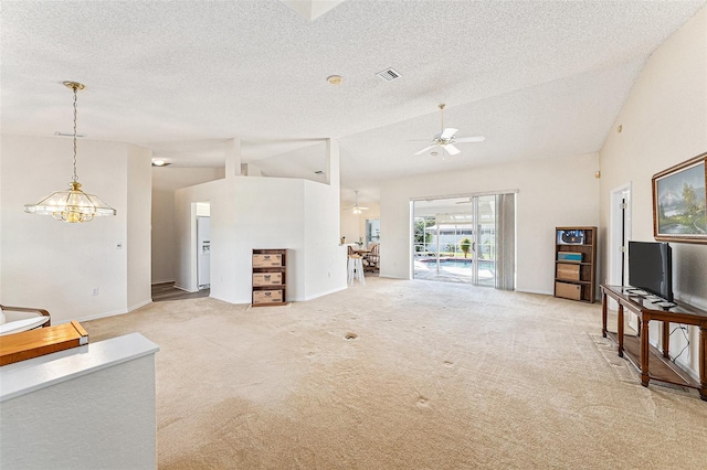 carpeted living room with ceiling fan with notable chandelier, high vaulted ceiling, and a textured ceiling