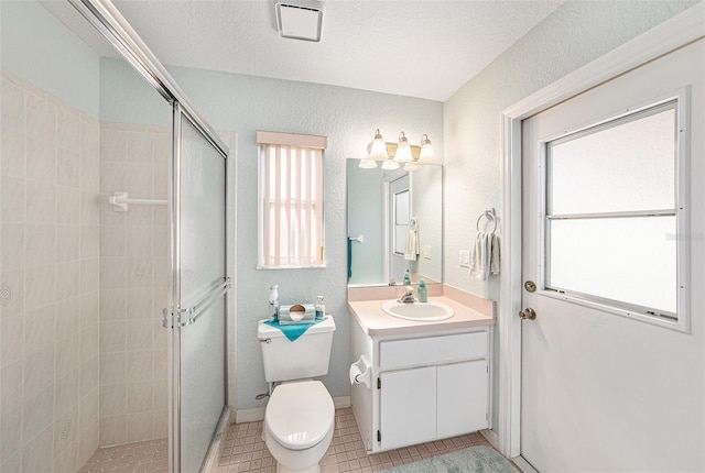 bathroom with vanity, a shower with shower door, toilet, and tile patterned flooring