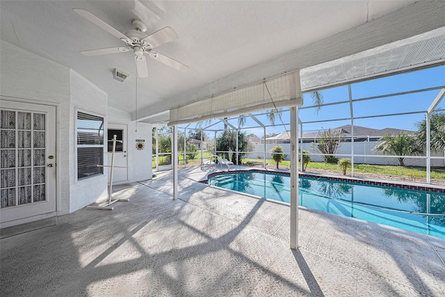 view of swimming pool with ceiling fan, a patio area, and a lanai