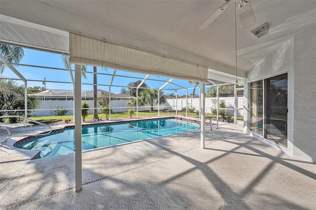 view of pool featuring glass enclosure, ceiling fan, and a patio area