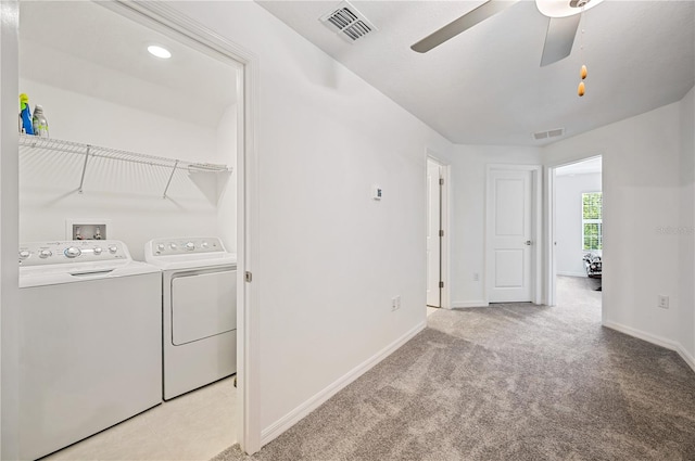 laundry area featuring separate washer and dryer, light carpet, and ceiling fan