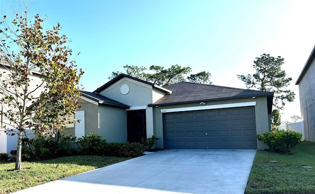 ranch-style home with driveway, a front lawn, an attached garage, and stucco siding