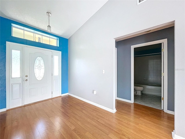 foyer entrance featuring light hardwood / wood-style floors and vaulted ceiling