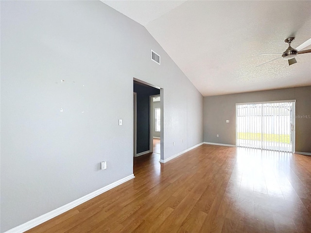 empty room featuring ceiling fan, wood-type flooring, a textured ceiling, and high vaulted ceiling