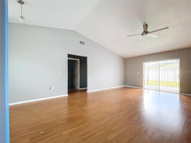 empty room featuring a textured ceiling, ceiling fan, lofted ceiling, and hardwood / wood-style flooring