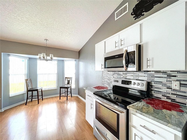 kitchen with pendant lighting, light hardwood / wood-style flooring, appliances with stainless steel finishes, white cabinetry, and a chandelier