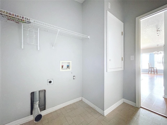 washroom with electric dryer hookup, hookup for a washing machine, a textured ceiling, and a notable chandelier