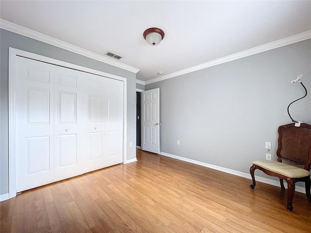 unfurnished bedroom featuring a closet, crown molding, and light hardwood / wood-style flooring