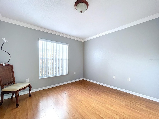 sitting room with ornamental molding and light wood-type flooring