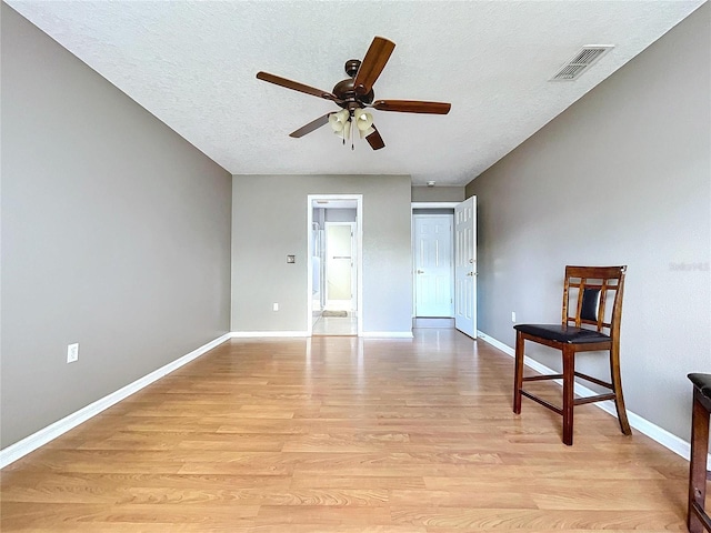 interior space with a textured ceiling, light hardwood / wood-style floors, and ceiling fan