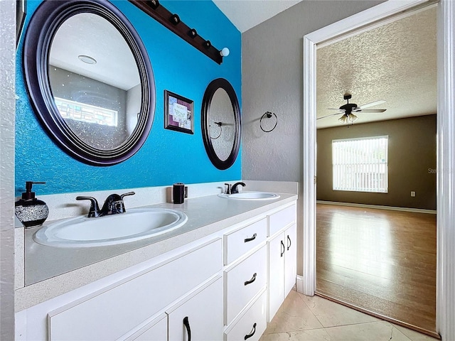 bathroom featuring hardwood / wood-style floors, vanity, a textured ceiling, and ceiling fan