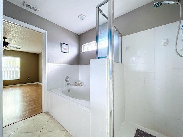 bathroom with ceiling fan, independent shower and bath, a textured ceiling, and hardwood / wood-style flooring