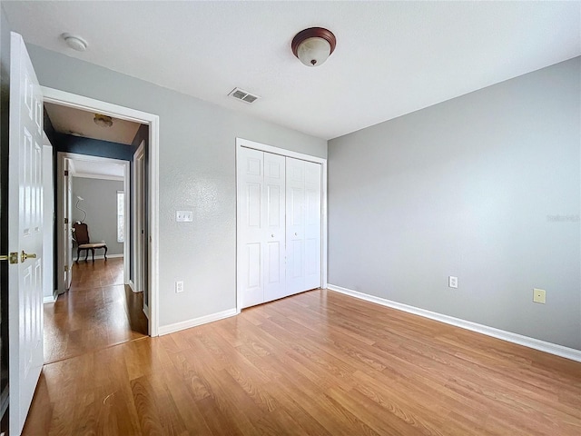 unfurnished bedroom with a closet and hardwood / wood-style floors